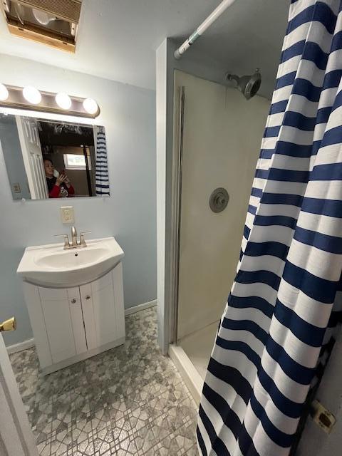 1269 Margaret St, Saint Paul, MN 55106 - full bathroom with curtained shower, vanity, and baseboards