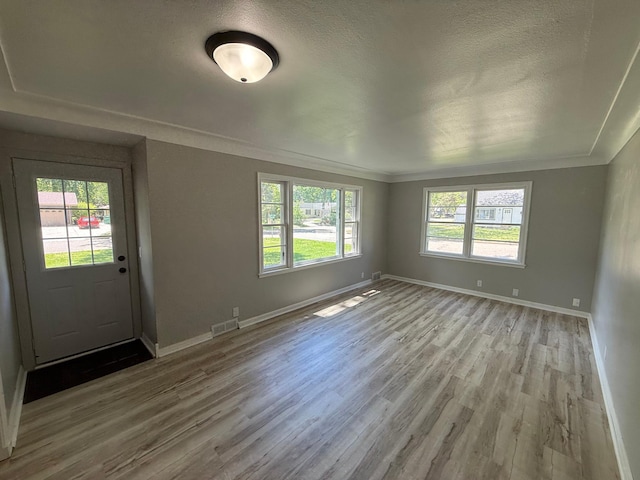 446 Darwin St, Litchfield, MN 55355 - empty room with wood finished floors, baseboards, crown molding, and a textured ceiling