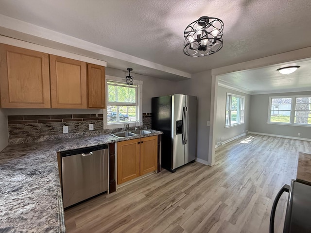 446 Darwin St, Litchfield, MN 55355 - kitchen featuring appliances with stainless steel finishes, a sink, light wood finished floors, a textured ceiling, and tasteful backsplash