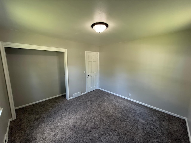 446 Darwin St, Litchfield, MN 55355 - unfurnished bedroom with dark colored carpet, baseboards, and a closet