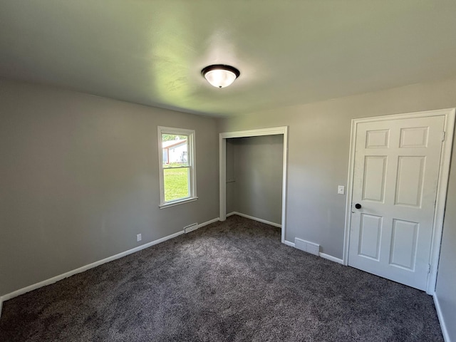 446 Darwin St, Litchfield, MN 55355 - unfurnished bedroom featuring dark colored carpet, baseboards, and a closet