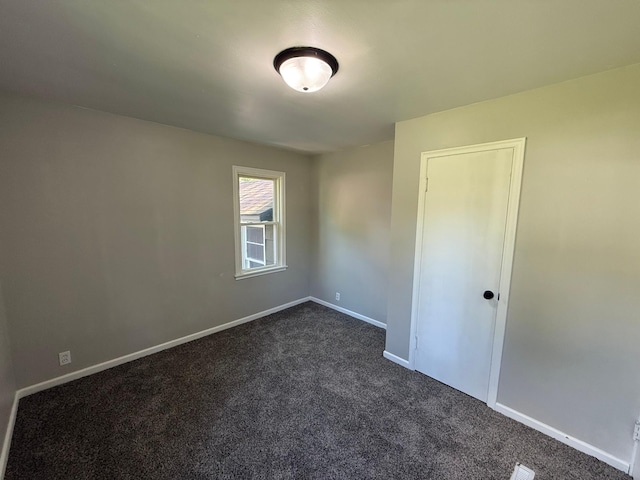 446 Darwin St, Litchfield, MN 55355 - empty room featuring dark carpet and baseboards