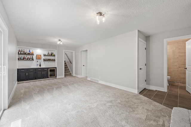 7190 Annapolis Cir, Maple Grove, MN 55311 - unfurnished living room featuring bar, carpet flooring, baseboards, stairway, and a textured ceiling