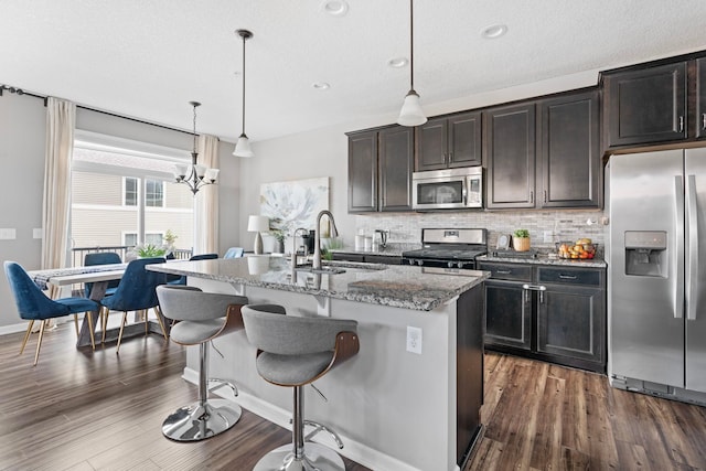 6980 Archer Trl, Inver Grove Heights, MN 55077 - kitchen with stainless steel appliances, a sink, light stone counters, an island with sink, and a kitchen breakfast bar