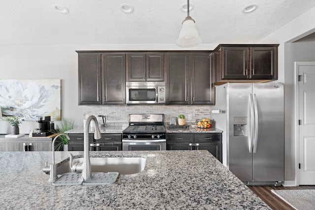 6980 Archer Trl, Inver Grove Heights, MN 55077 - kitchen with appliances with stainless steel finishes, a sink, light stone counters, dark brown cabinetry, and a textured ceiling