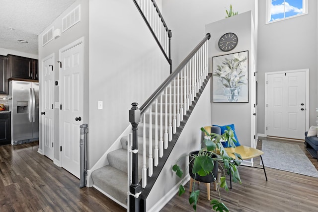 6980 Archer Trl, Inver Grove Heights, MN 55077 - foyer entrance featuring stairway, a high ceiling, dark wood finished floors, a textured ceiling, and baseboards