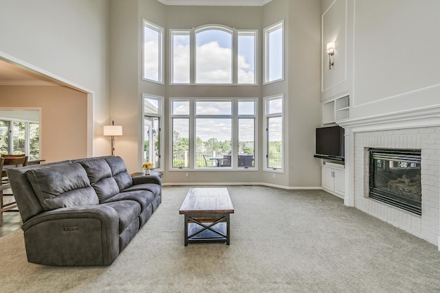 3877 Fairway Dr, Woodbury, MN 55125 - living area featuring a towering ceiling, carpet flooring, a brick fireplace, crown molding, and baseboards