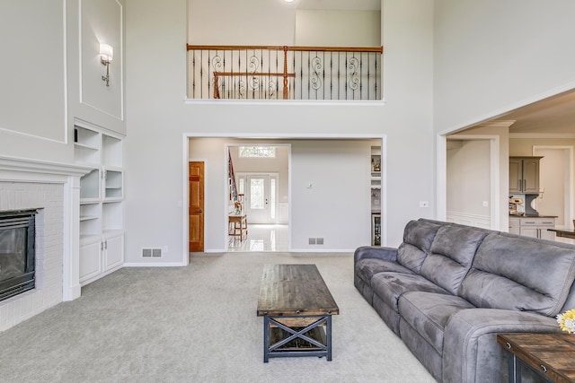 3877 Fairway Dr, Woodbury, MN 55125 - living room featuring carpet floors, a high ceiling, built in features, baseboards, and a fireplace