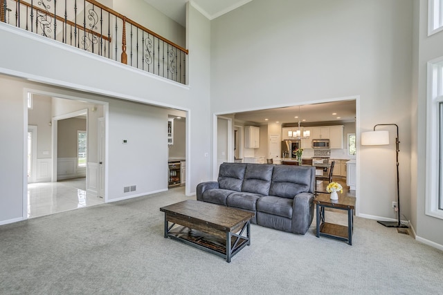 3877 Fairway Dr, Woodbury, MN 55125 - living area featuring a towering ceiling, light carpet, a chandelier, wine cooler, and baseboards