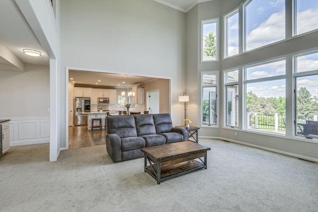 3877 Fairway Dr, Woodbury, MN 55125 - living area with light colored carpet, a high ceiling, a chandelier, crown molding, and baseboards