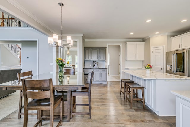 3877 Fairway Dr, Woodbury, MN 55125 - dining space featuring stairway, crown molding, light wood-style floors, a chandelier, and recessed lighting