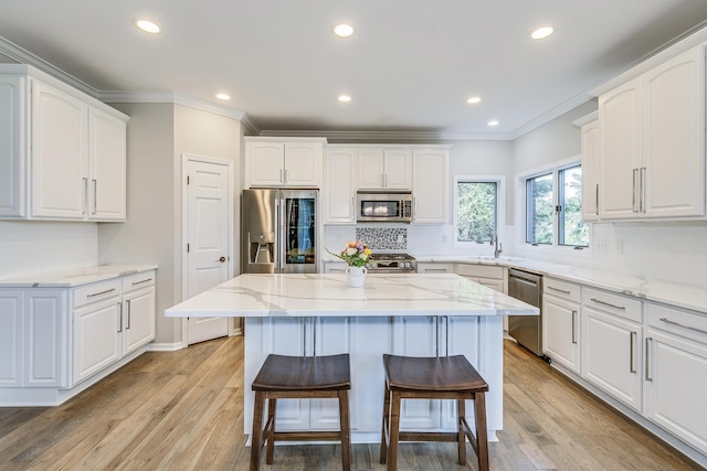 3877 Fairway Dr, Woodbury, MN 55125 - kitchen with stainless steel appliances, a kitchen breakfast bar, white cabinetry, ornamental molding, and decorative backsplash