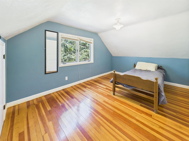 302 2nd St S, Melrose, MN 56352 - bedroom with wood-type flooring, lofted ceiling, and baseboards