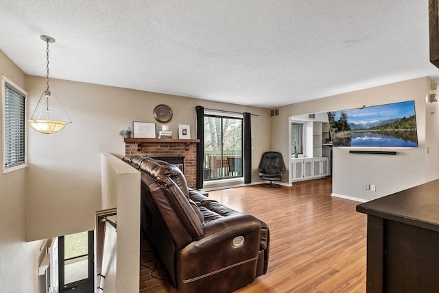 445 Shelard Pkwy Unit 204, Saint Louis Park, MN 55426 - living area featuring a textured ceiling, light wood-type flooring, a brick fireplace, and baseboards