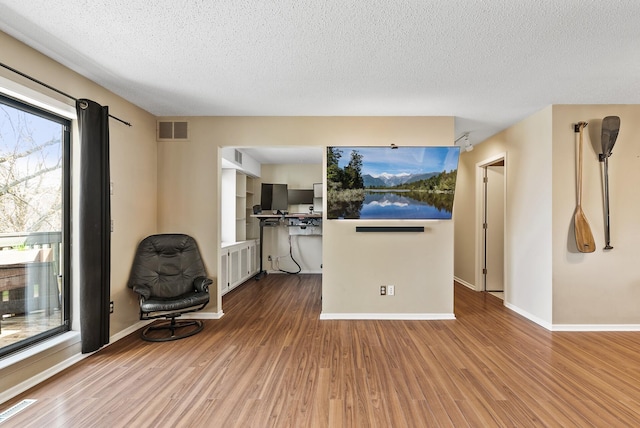 445 Shelard Pkwy Unit 204, Saint Louis Park, MN 55426 - unfurnished living room with wood finished floors, a textured ceiling, radiator heating unit, and baseboards