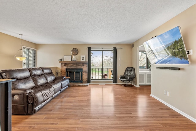 445 Shelard Pkwy Unit 204, Saint Louis Park, MN 55426 - living area with light wood-style floors, a textured ceiling, healthy amount of natural light, a brick fireplace, and baseboards