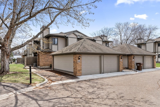 445 Shelard Pkwy Unit 204, Saint Louis Park, MN 55426 - view of front of property featuring brick siding, a chimney, and an attached garage