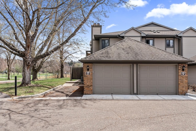 445 Shelard Pkwy Unit 204, Saint Louis Park, MN 55426 - view of property exterior with a chimney, a garage, brick siding, and a shingled roof