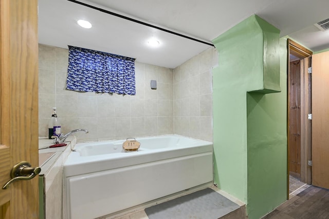 2221 Texas Ave S, Saint Louis Park, MN 55426 - bathroom featuring a garden tub, tile walls, recessed lighting, and wood finished floors