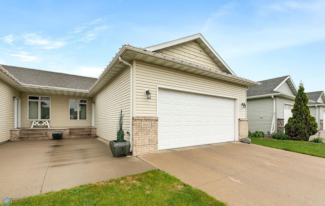 4465 53rd St S, Fargo, ND 58104 - view of side of home with driveway, an attached garage, brick siding, and a porch