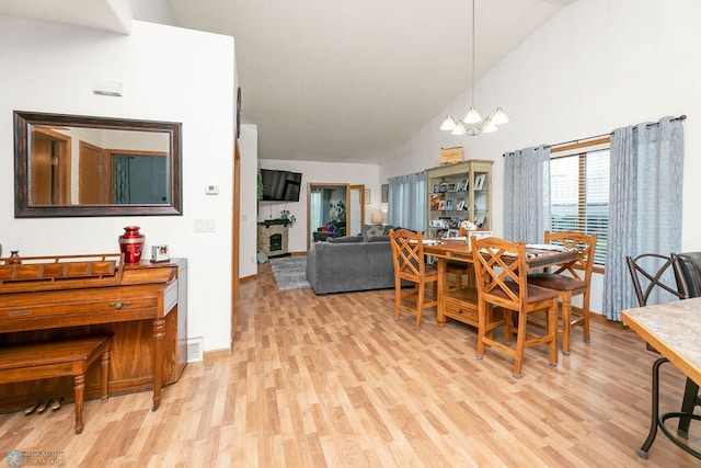 4465 53rd St S, Fargo, ND 58104 - dining space with light wood-type flooring, a chandelier, high vaulted ceiling, and baseboards
