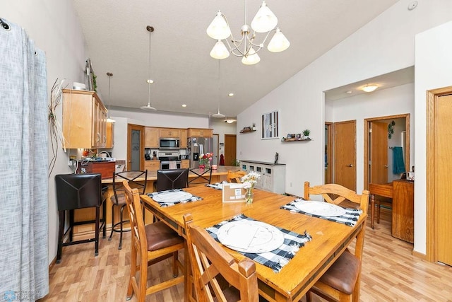 4465 53rd St S, Fargo, ND 58104 - dining area featuring vaulted ceiling, light wood-style flooring, and a chandelier