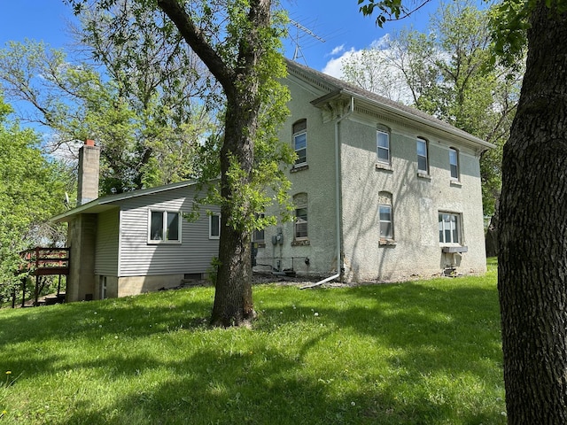 6950 270th St, New Prague, MN 56071 - view of property exterior with a chimney, a yard, and stucco siding