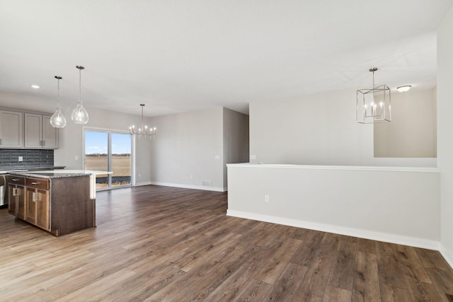 2701 213th St W, Farmington, MN 55024 - kitchen featuring a chandelier, wood finished floors, open floor plan, baseboards, and tasteful backsplash