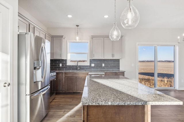 2701 213th St W, Farmington, MN 55024 - kitchen with appliances with stainless steel finishes, tasteful backsplash, recessed lighting, a center island, and light stone countertops