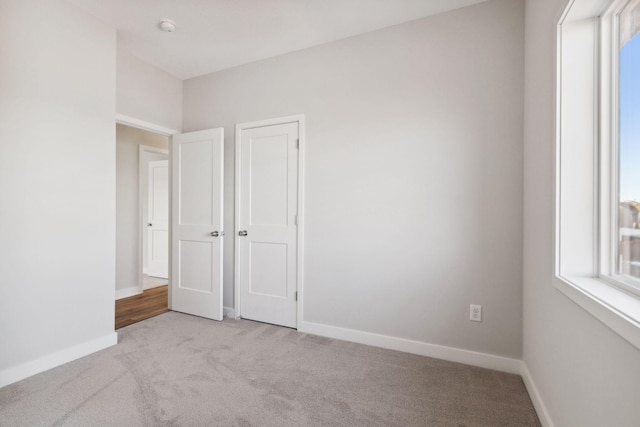 2701 213th St W, Farmington, MN 55024 - unfurnished bedroom featuring light carpet, multiple windows, and baseboards