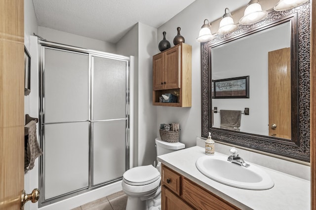 15144 Zilla St NW, Andover, MN 55304 - bathroom with a stall shower, vanity, toilet, a textured ceiling, and tile patterned floors