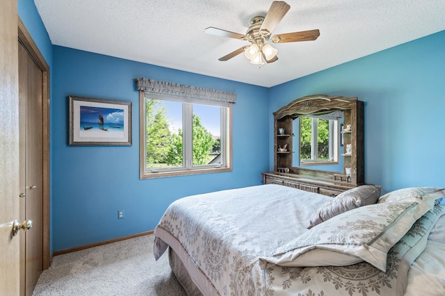 15144 Zilla St NW, Andover, MN 55304 - bedroom with multiple windows, baseboards, light colored carpet, a textured ceiling, and ceiling fan