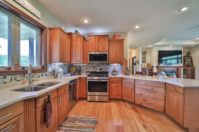 23369 330th St, Sebeka, MN 56477 - kitchen with stainless steel appliances, a sink, light countertops, a peninsula, and light wood-style flooring