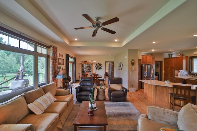 23369 330th St, Sebeka, MN 56477 - living room with ceiling fan, a chandelier, light wood finished floors, recessed lighting, and a tray ceiling