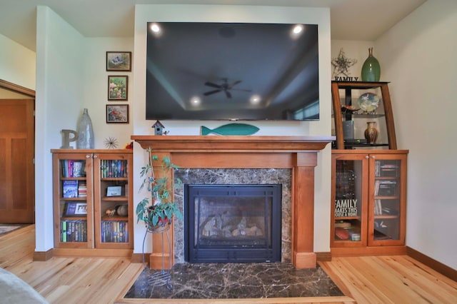 23369 330th St, Sebeka, MN 56477 - living room featuring wood finished floors, a high end fireplace, a ceiling fan, baseboards, and recessed lighting
