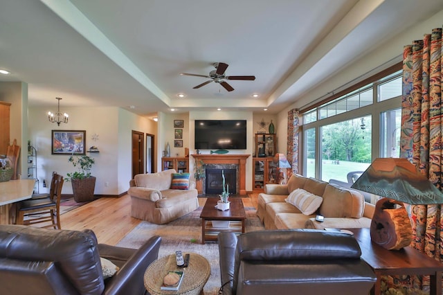 23369 330th St, Sebeka, MN 56477 - living room with wood finished floors, ceiling fan, a premium fireplace, a chandelier, and a raised ceiling