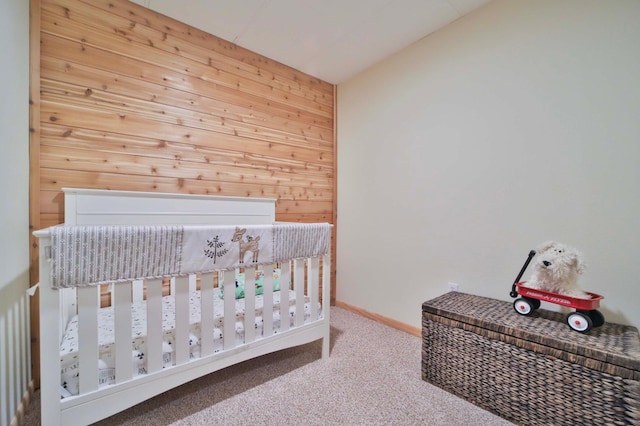 23369 330th St, Sebeka, MN 56477 - bedroom with carpet, wood walls, a crib, and baseboards
