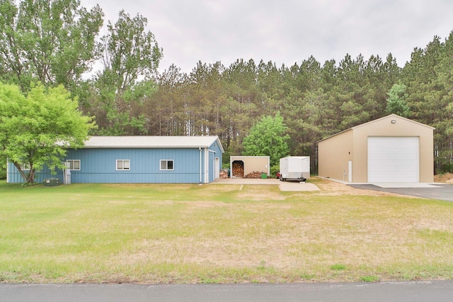 23369 330th St, Sebeka, MN 56477 - view of grassy yard featuring a garage, an outdoor structure, and a view of trees