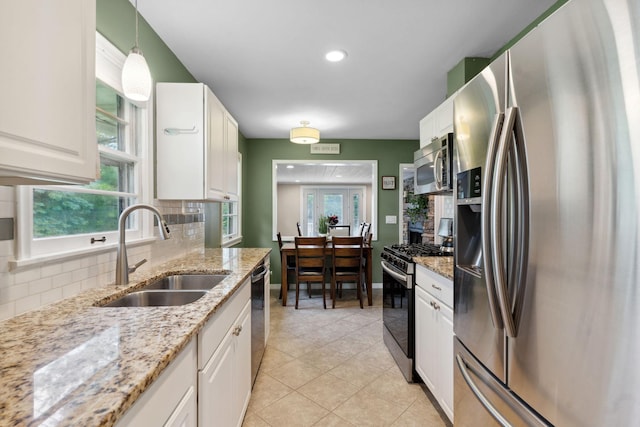 3732 Jersey Ave N, Crystal, MN 55427 - kitchen with stainless steel appliances, white cabinets, backsplash, decorative light fixtures, and light tile patterned floors
