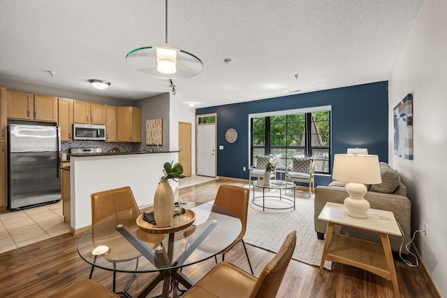 2566 Ellis Ave Unit 124, Saint Paul, MN 55114 - dining room with light wood-style flooring, a textured ceiling, ceiling fan, and baseboards