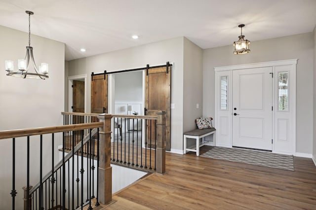 18022 Urbank St NE, Ham Lake, MN 55304 - entryway with a chandelier, wood finished floors, a barn door, recessed lighting, and baseboards