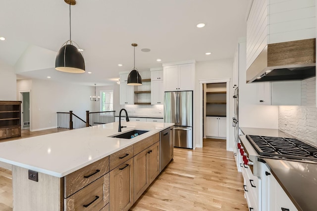18022 Urbank St NE, Ham Lake, MN 55304 - kitchen featuring appliances with stainless steel finishes, a sink, custom range hood, backsplash, and light wood-style flooring