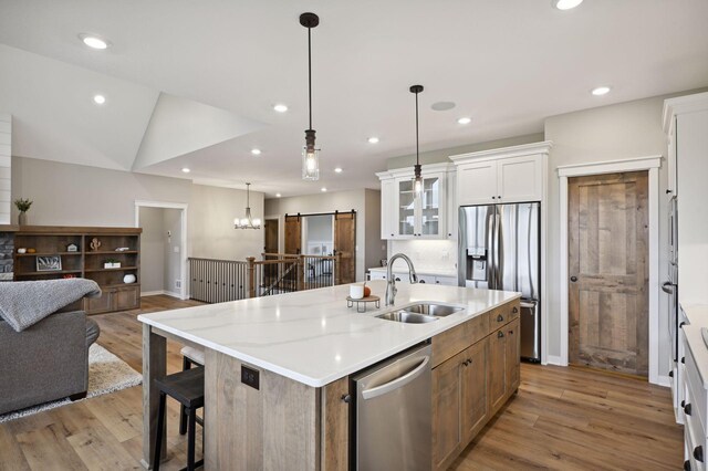 18022 Urbank St NE, Ham Lake, MN 55304 - kitchen with appliances with stainless steel finishes, a sink, white cabinets, light wood-style floors, and open floor plan