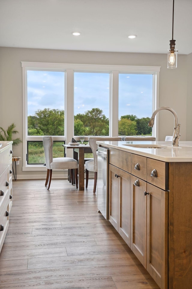 18022 Urbank St NE, Ham Lake, MN 55304 - kitchen featuring a sink, light countertops, dishwasher, hanging light fixtures, and light wood-type flooring