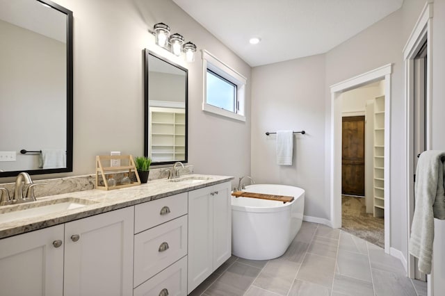 18022 Urbank St NE, Ham Lake, MN 55304 - full bathroom with double vanity, a soaking tub, a spacious closet, baseboards, and recessed lighting
