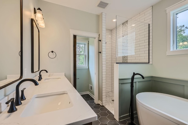 18022 Urbank St NE, Ham Lake, MN 55304 - bathroom with a shower stall, a soaking tub, double vanity, a wainscoted wall, and tile patterned floors
