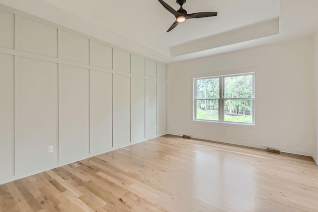 18022 Urbank St NE, Ham Lake, MN 55304 - unfurnished bedroom with light wood-style flooring, a raised ceiling, ceiling fan, and baseboards