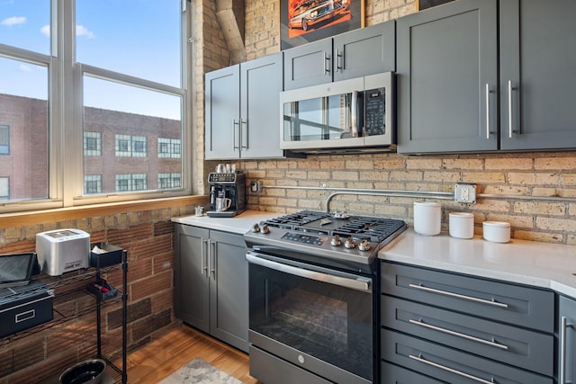 901 3rd St Unit 411, Minneapolis, MN 55401 - kitchen with appliances with stainless steel finishes, gray cabinets, light countertops, and light wood finished floors