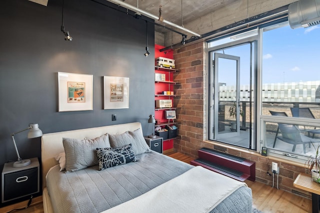 901 3rd St Unit 411, Minneapolis, MN 55401 - bedroom with wood finished floors, brick wall, and rail lighting