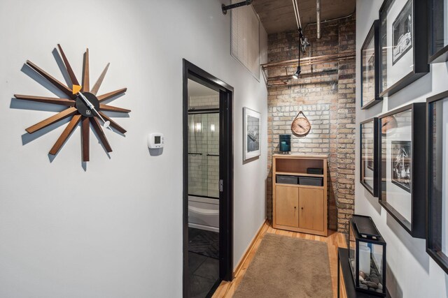 901 3rd St Unit 411, Minneapolis, MN 55401 - corridor with light wood-style floors, a high ceiling, brick wall, and baseboards